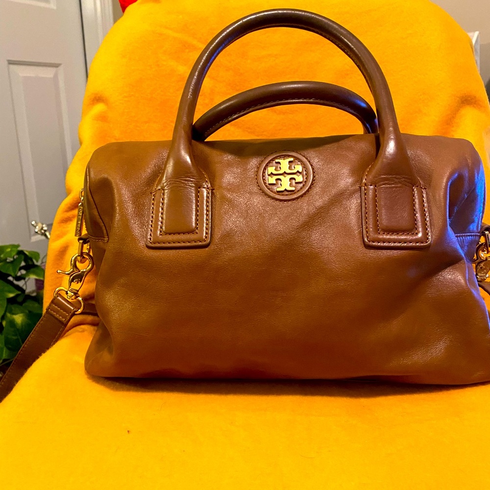 Practically new duffle bag with gold assessories and cross body strap.